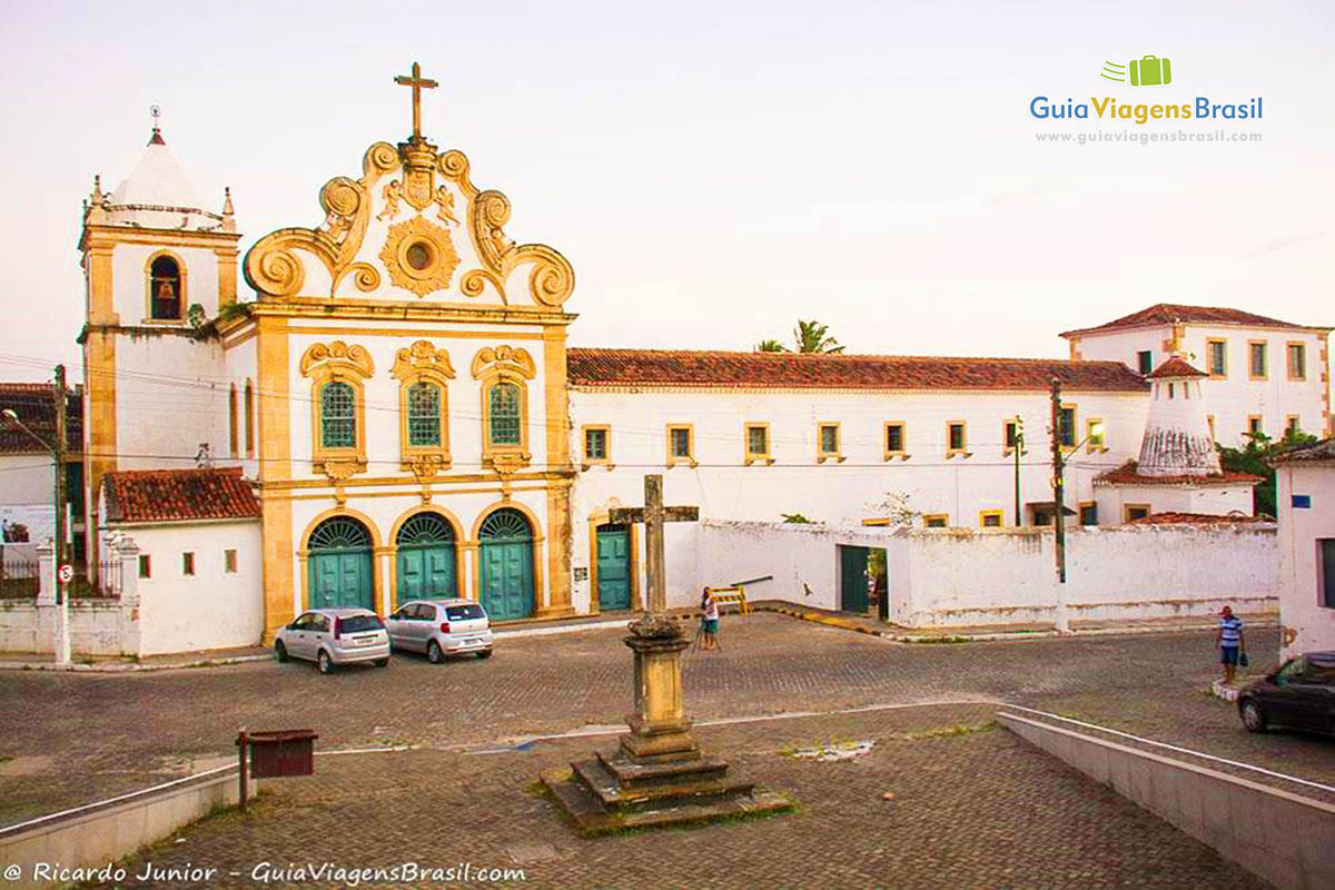 Imagem de toda faixada do Convento Nossa Senhora dos Anjos, na frente crucifixo deixando a paisagem mais completa, religião e beleza, em Penedo, Alagoas, Brasil.