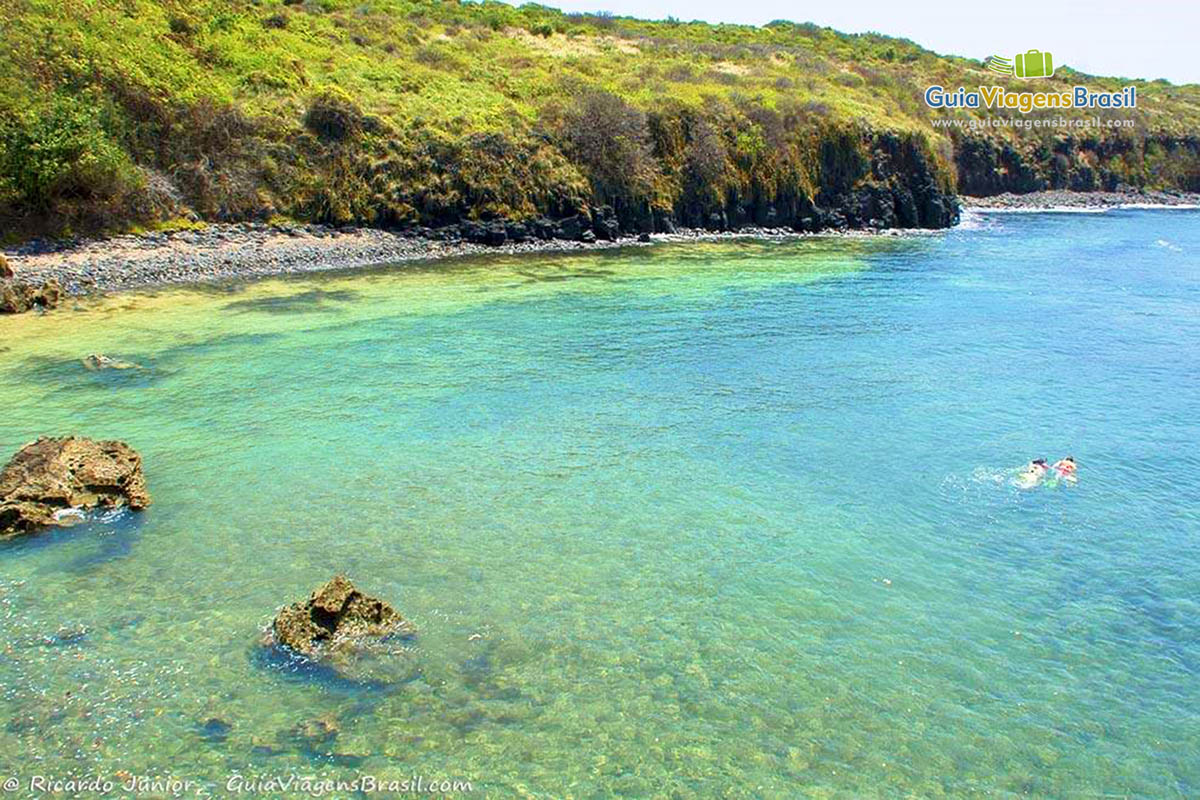 Imagem de turistas mergulhando na piscina natural de Ponta das Caracas, em Fernando de Noronha, Pernambuco, Brasil.