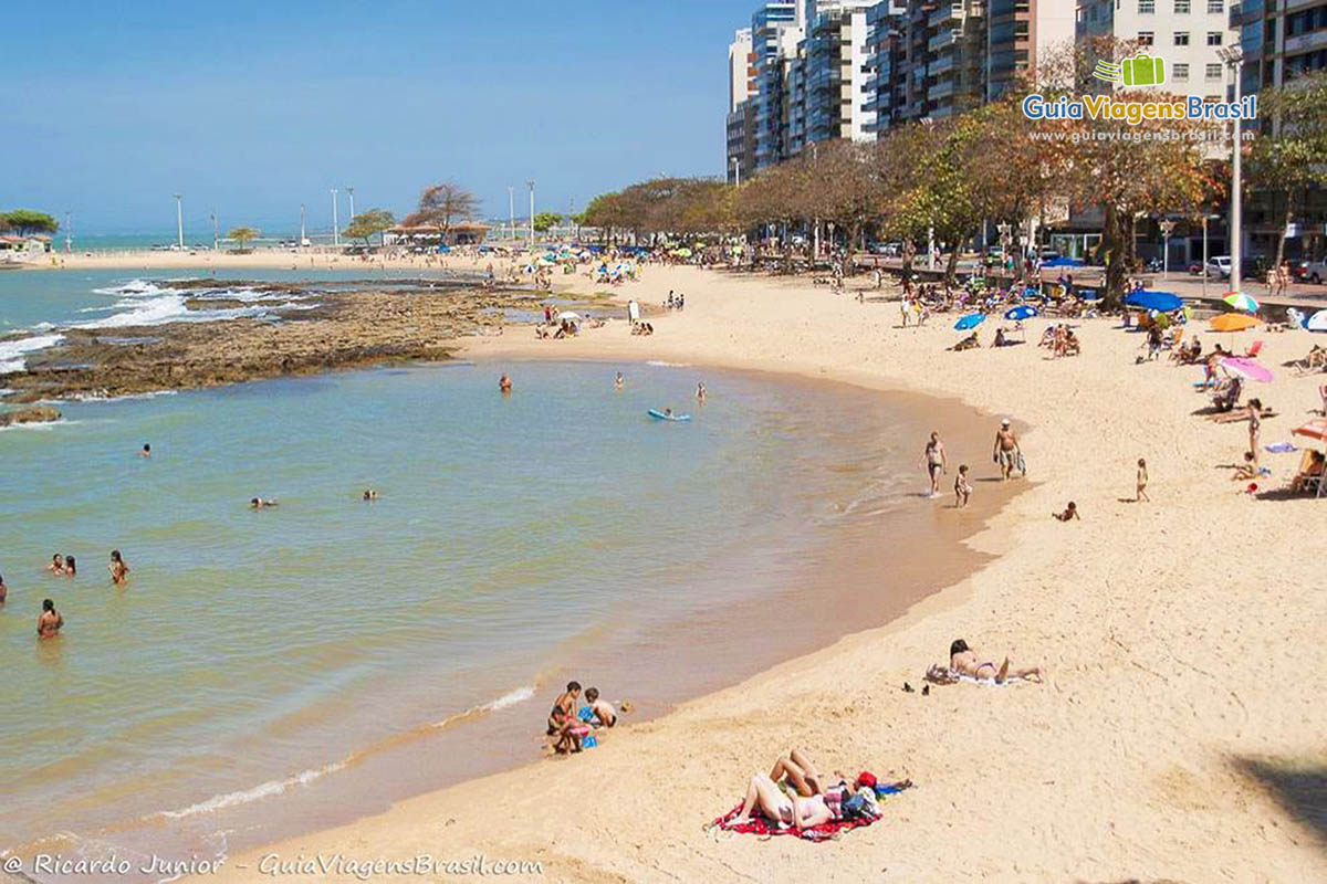 Imagem das pessoas curtindo um dia ensolarado na praia.