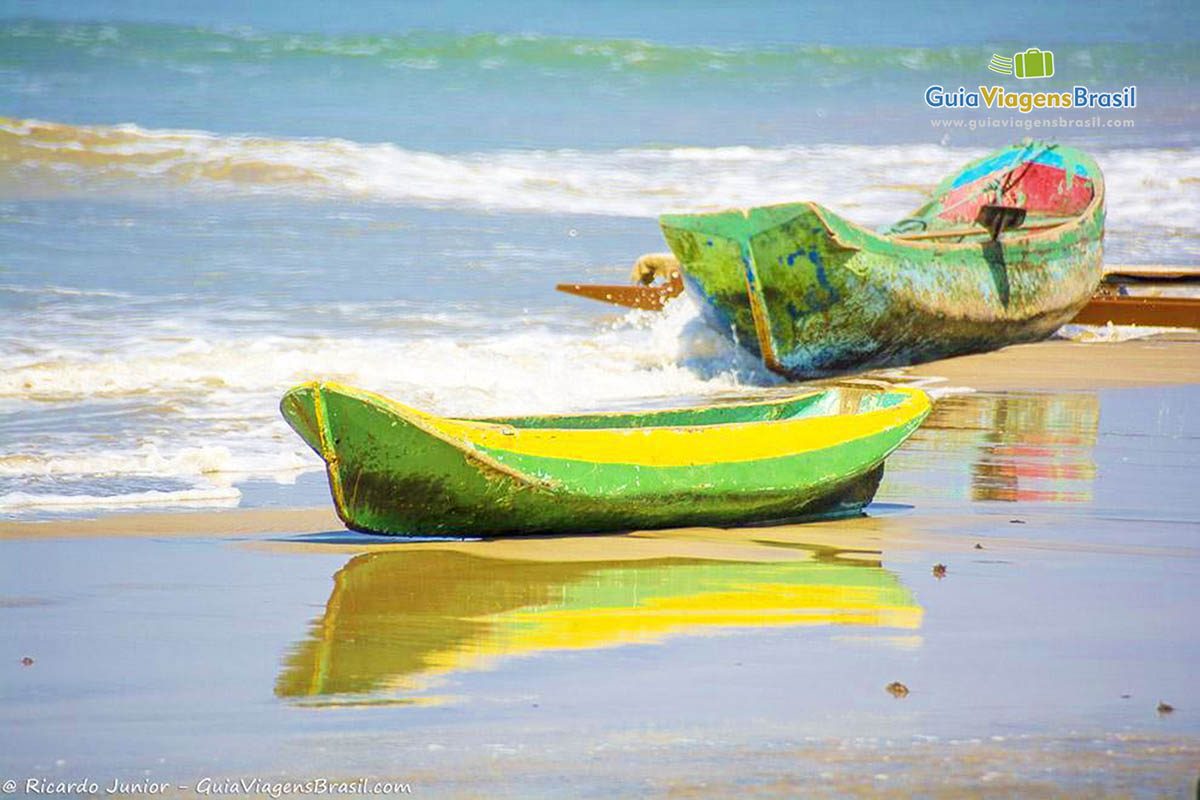 Imagem de barcos refletindo na beira da Praia de Castelhanos.