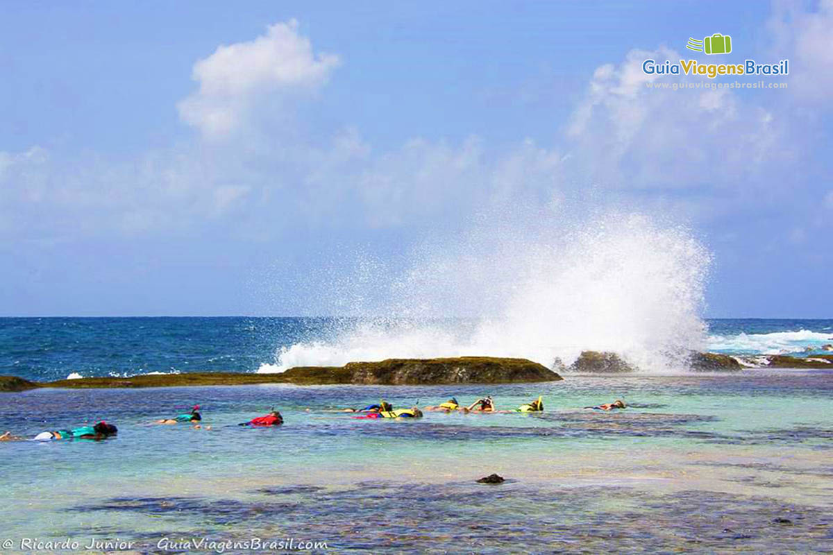 Imagem dos turistas se divertindo na Praia da Atalaia, em Fernando de Noronha, Pernambuco, Brasil.