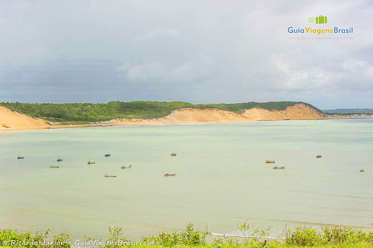 Imagem do mar com barcos de pescadores, na Praia da Baía Formosa.