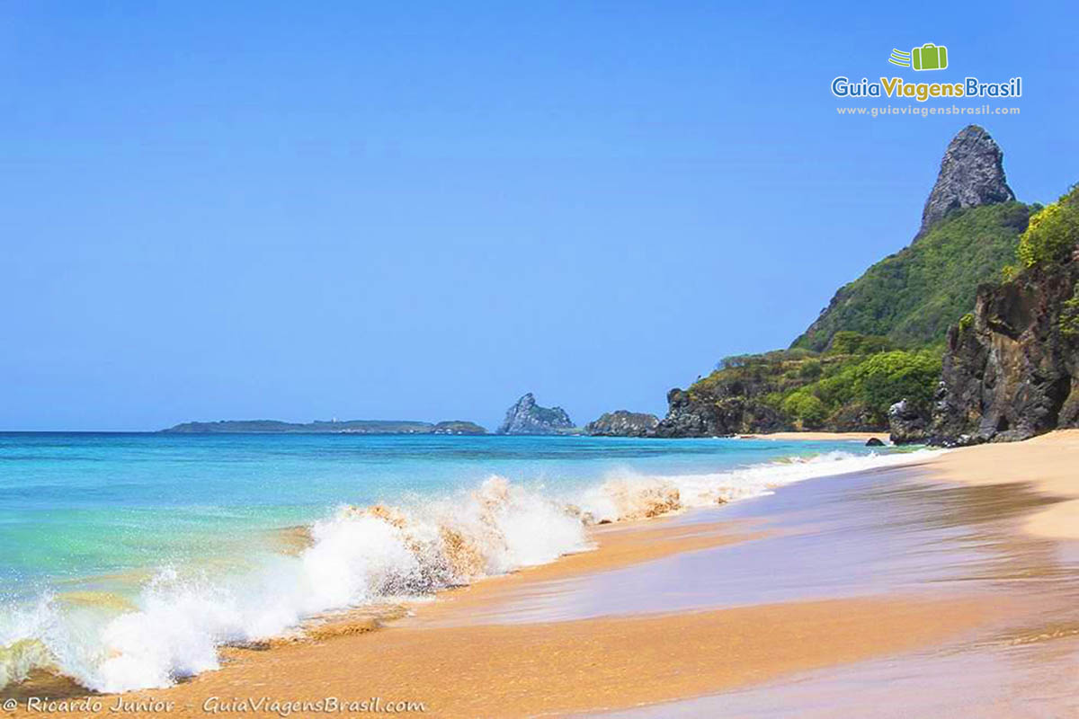 Imagem de ondas quebrando na beira do mar, na Praia da Cacimba do Padre, em Fernando de Noronha, Pernambuco, Brasil.