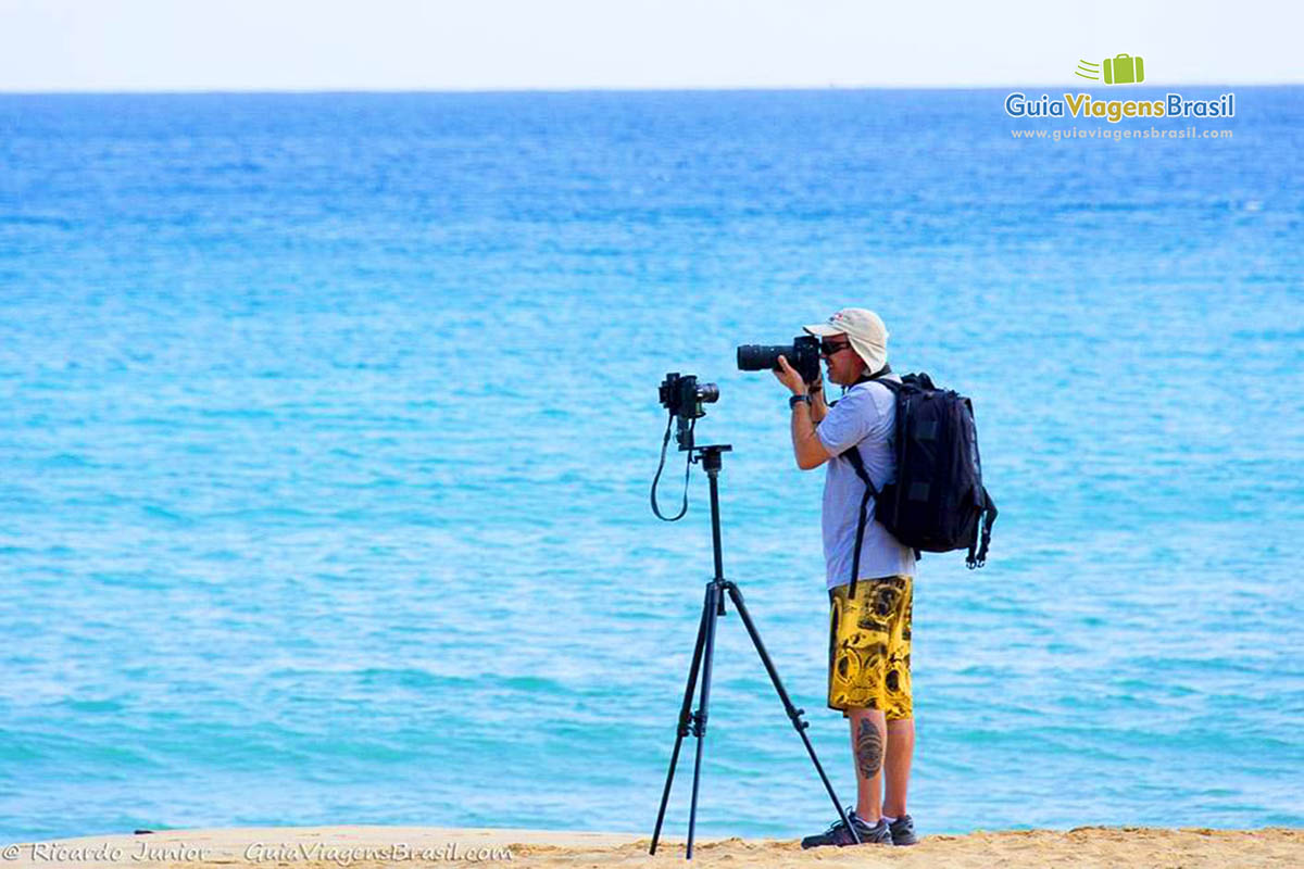 Imagem de um fotógrafo tirando foto das belezas de Fernando de Noronha, na Praia da Conceição, Pernambuco, Brasil.