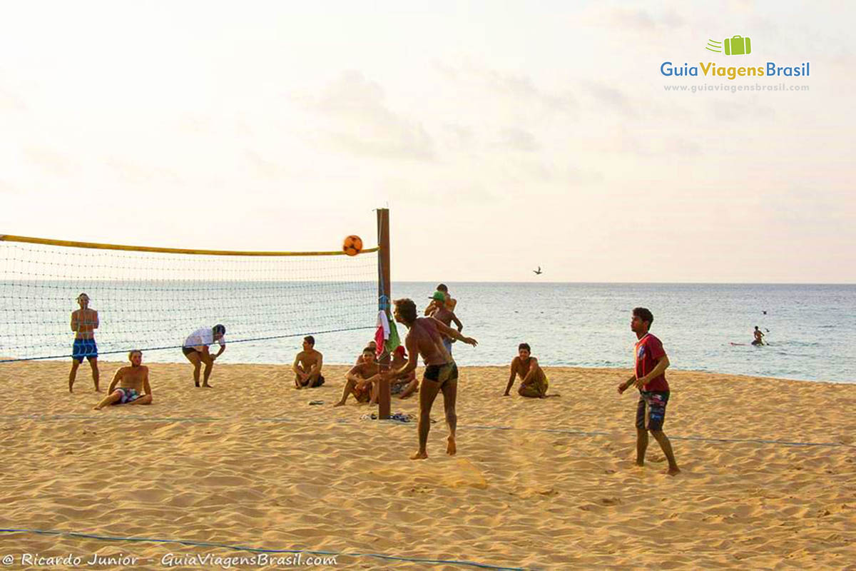 Imagem de um futevolei concorrido, pessoas sentadas na areia assistindo a partida, na Praia da Conceição,  em Fernando de  Noronha, Pernambuco, Brasil.