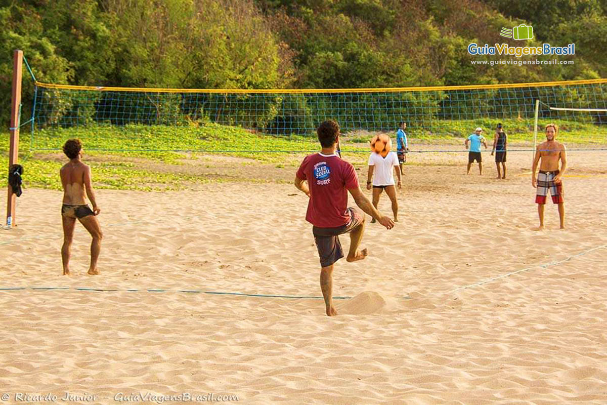 Imagem de meninos jogando futevolei na Praia da Conceição, em Fernando de Noronha, Pernambuco, Brasil.
