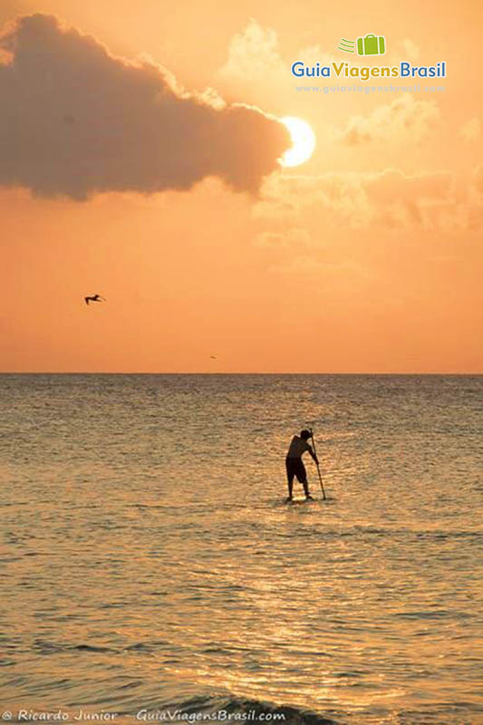 Imagem de turistas aproveitando até últimos minutos da tarde, na Praia da Conceição, em Fernando de Noronha, Pernambuco, Brasil.