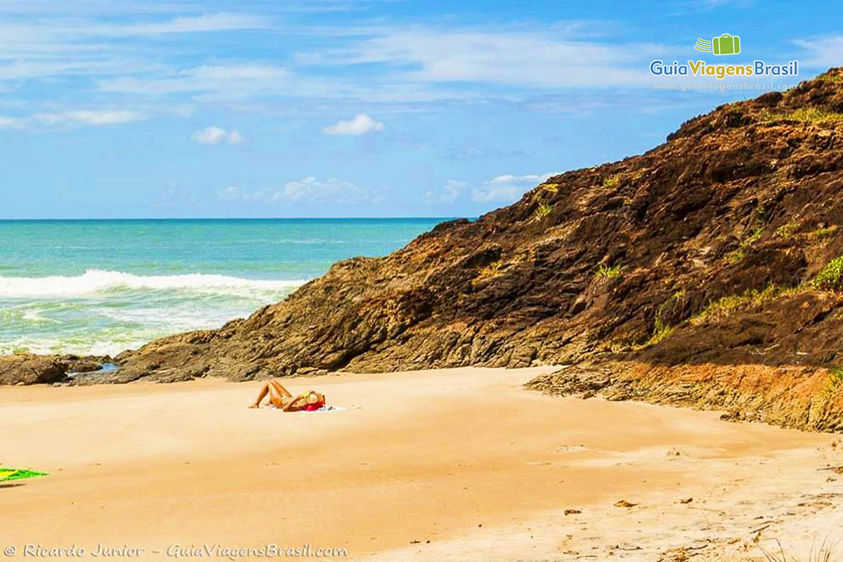 Imagem de turista aproveitando um dia de sol na praia.