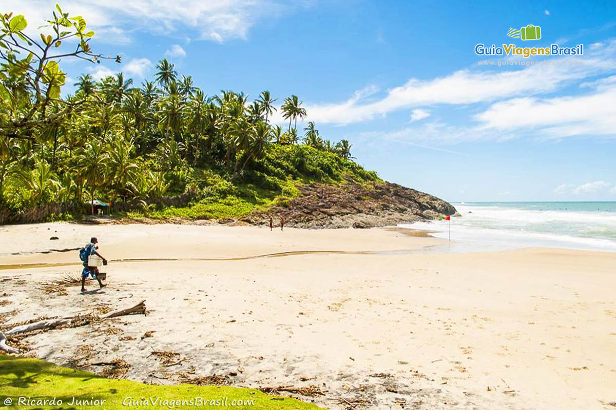 Imagem de um vendedor nas areias da praia, em Itacaré.