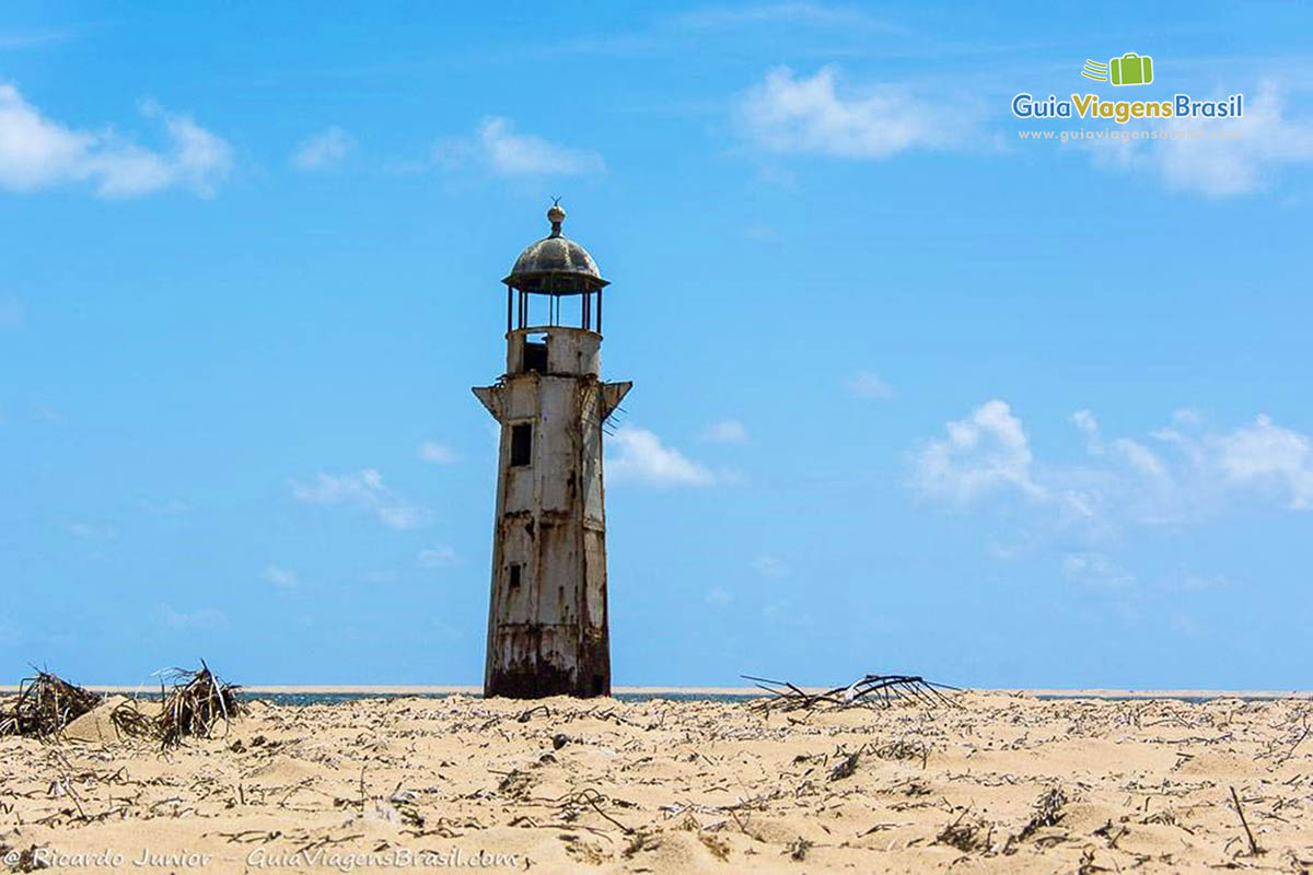 Imagem das areias claras e ao fundo o Farol.