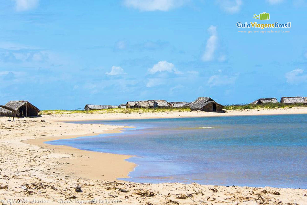 Imagem da Praia Foz Rio São Francisco e ao fundo as ocas de pescadores, Foz Rio São Francisco, em Alagoas, Brasil.