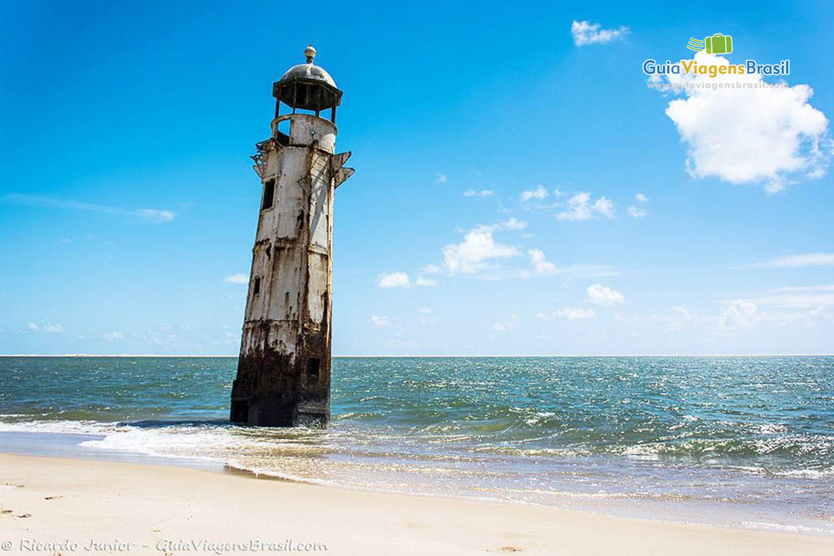 Imagem da praia de Foz Rio São Francisco e no mar o Farol desativado, em Alagoas, Brasil. 