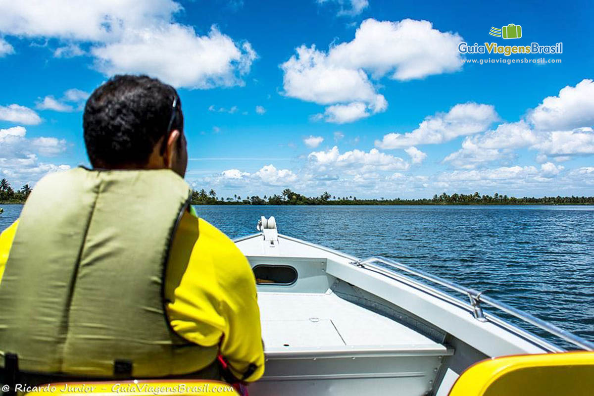 Imagem de um motorista pilotando uma lancha, Foz Rio São Francisco, em Alagoas, Brasil.