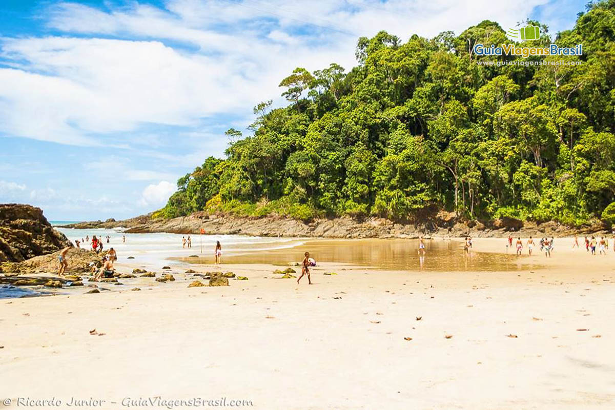 Imagem de turistas aproveitando belo dia de sol na Praia da Ribeira.