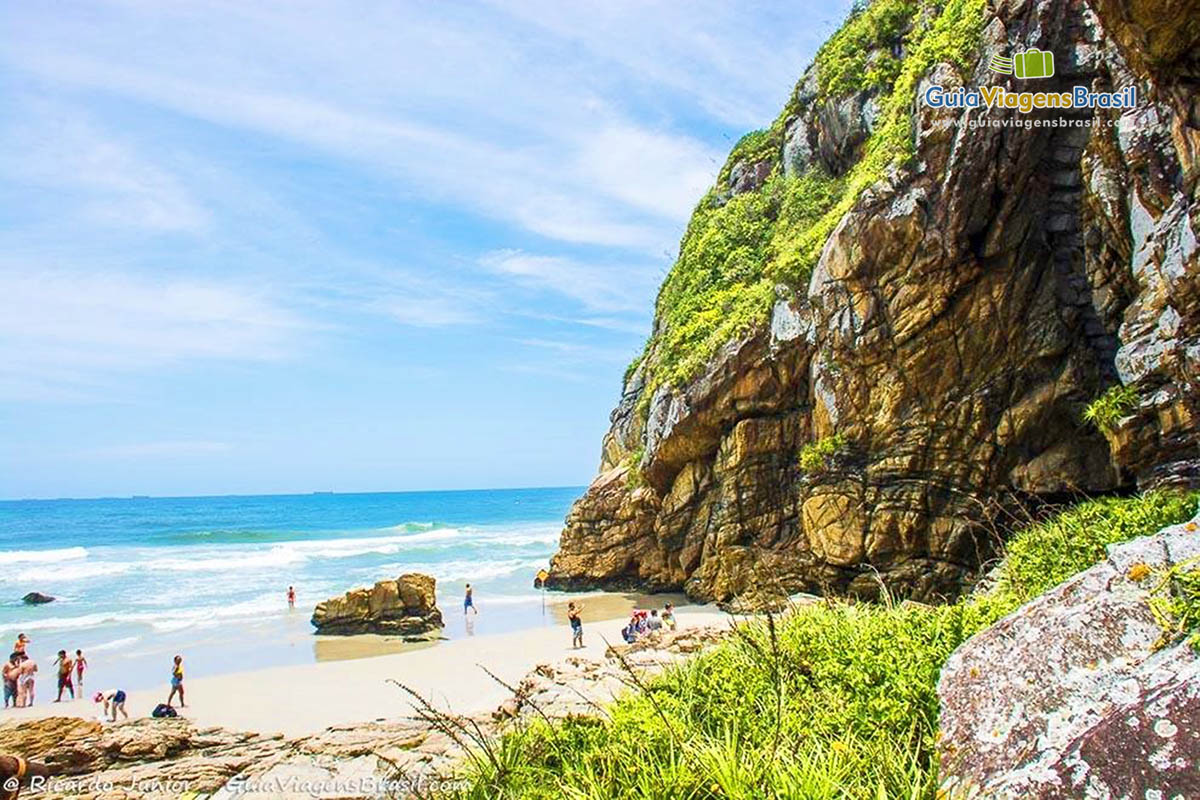 Imagem de turistas explorando a Praia das Encantadas, na Ilha do Mel, Paraná, Brasil.