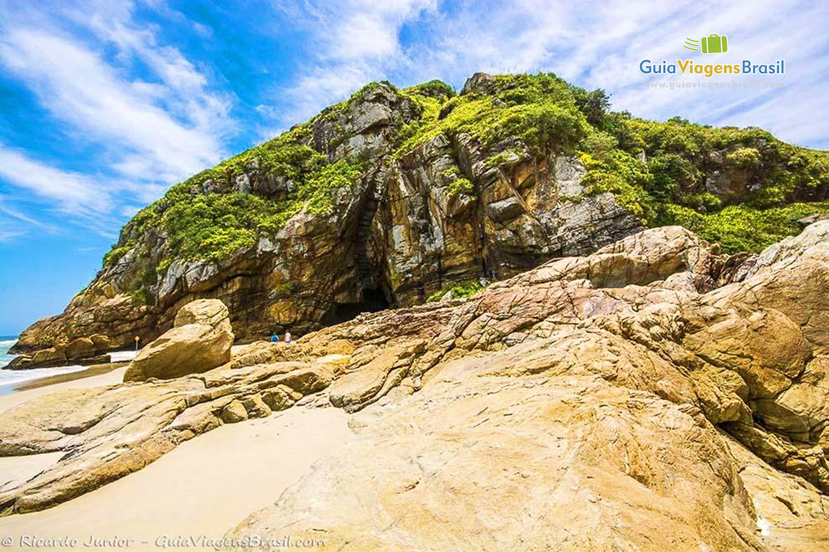 Imagem das pedras com vegetação em cima, na Praia da Encantadas, na Ilha do Mel, Paraná, Brasil.