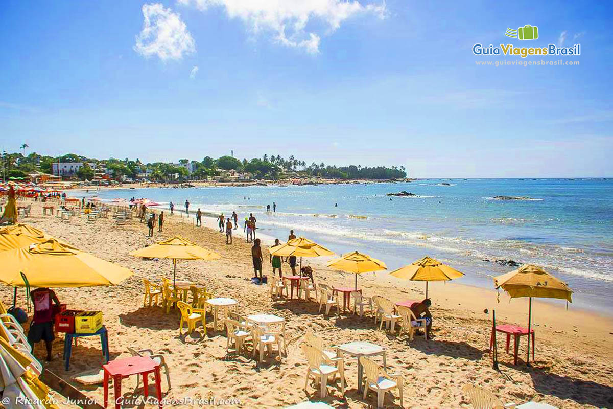 Imagem de guarda-sol amarelos nas areias da Praia de Itapuã.