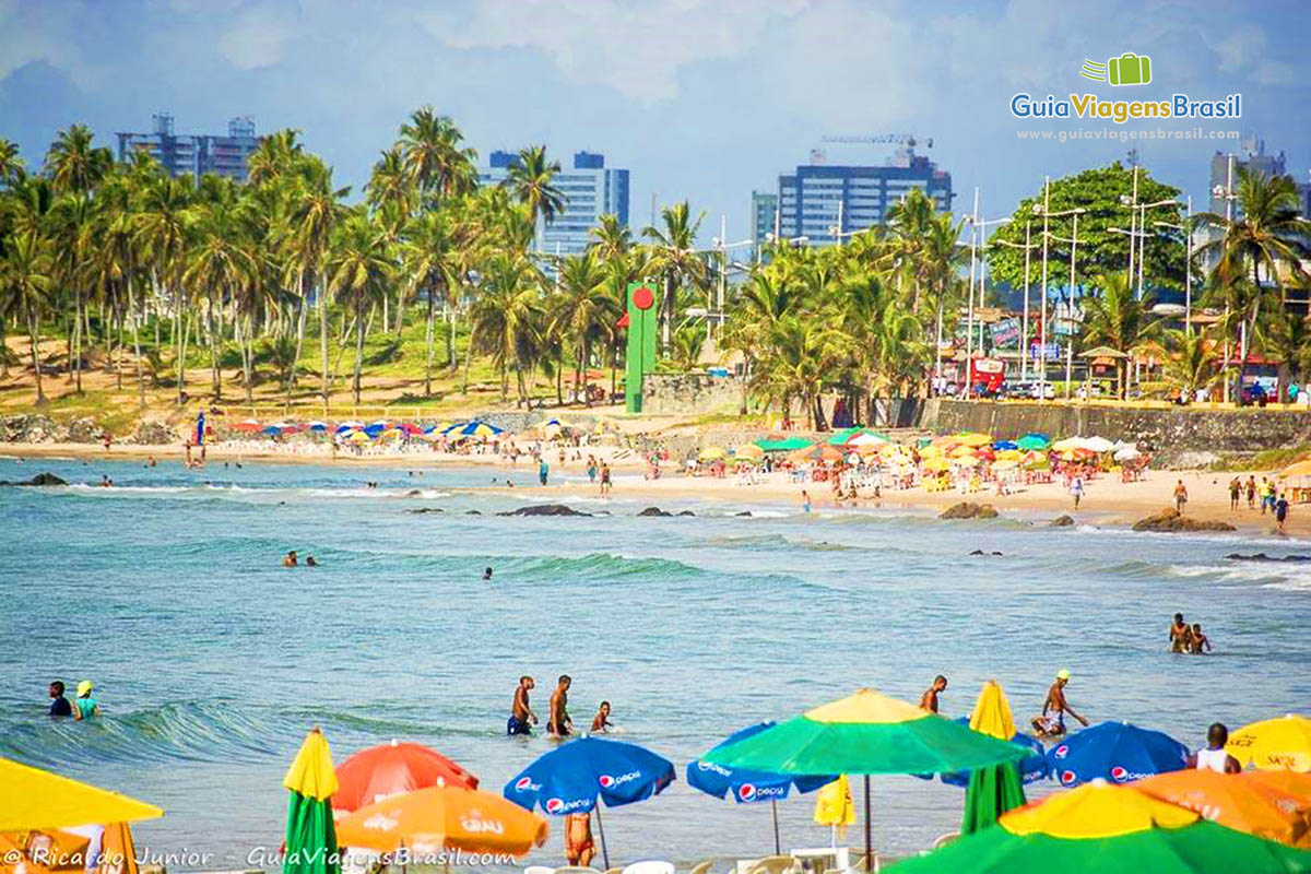 Imagem de guarda-sol coloridos e ao fundo o belo mar da Praia de Itapuã, em Sanvador.