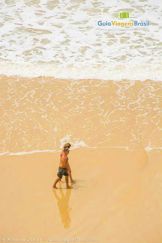 Imagem de turistas caminhando na beira do mar, em Tibau do Sul.