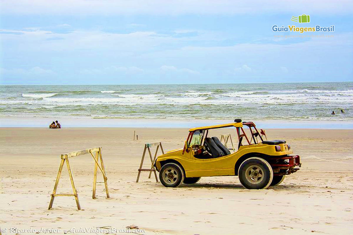 Imagem buggy na areia da praia e ao fundo o mar.