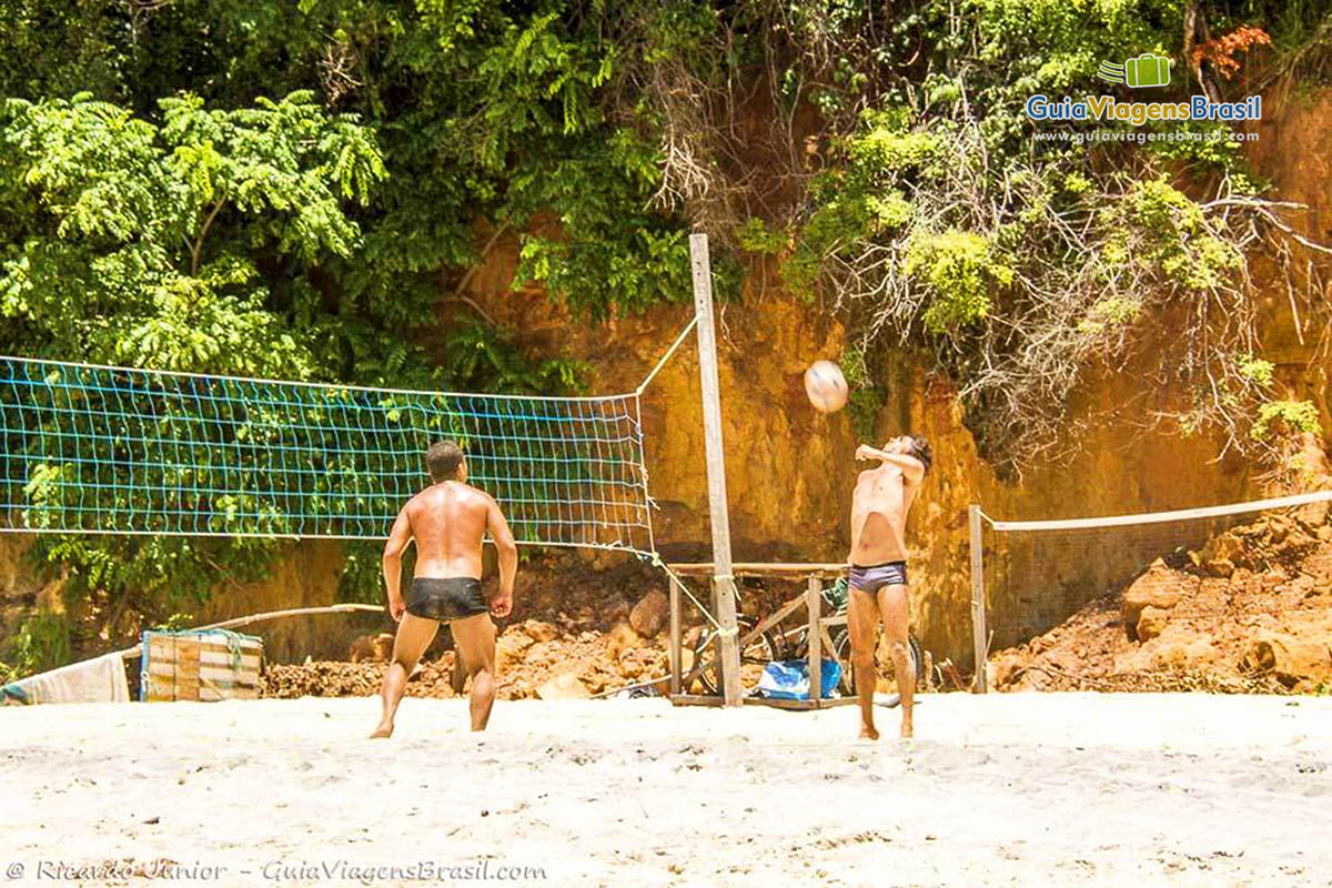 Imagem de pessoas jogando futevôlei na Praia de Pipa.