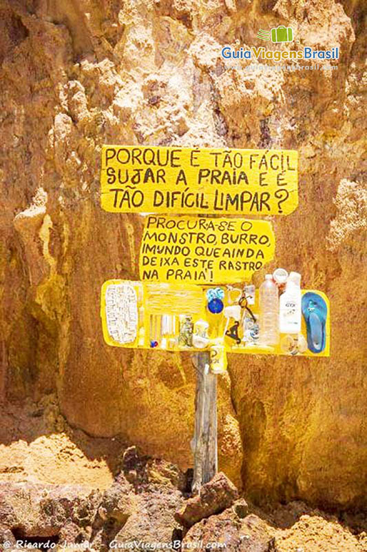 Imagem de uma placa dando alerta aos visitantes em deixar sujeira na praia.