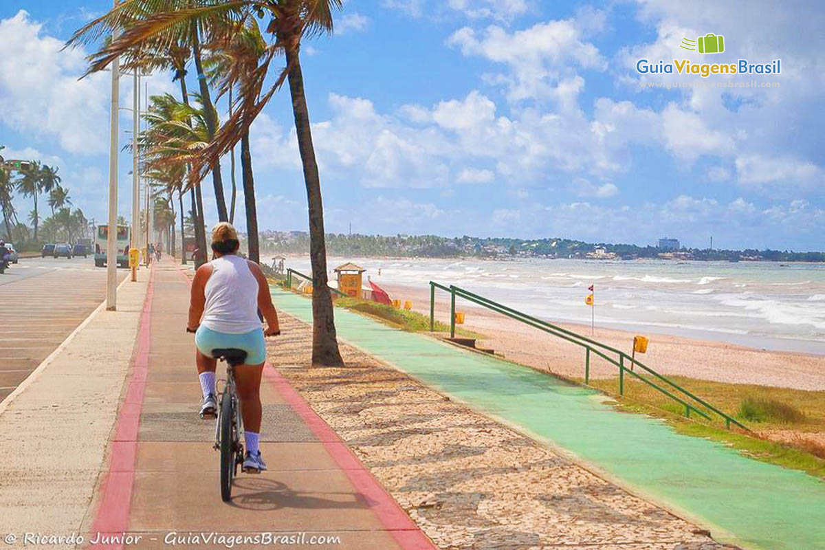 Imagem de uma pessoas andando de bicicleta na ciclovia da Praia de Pituaçu.