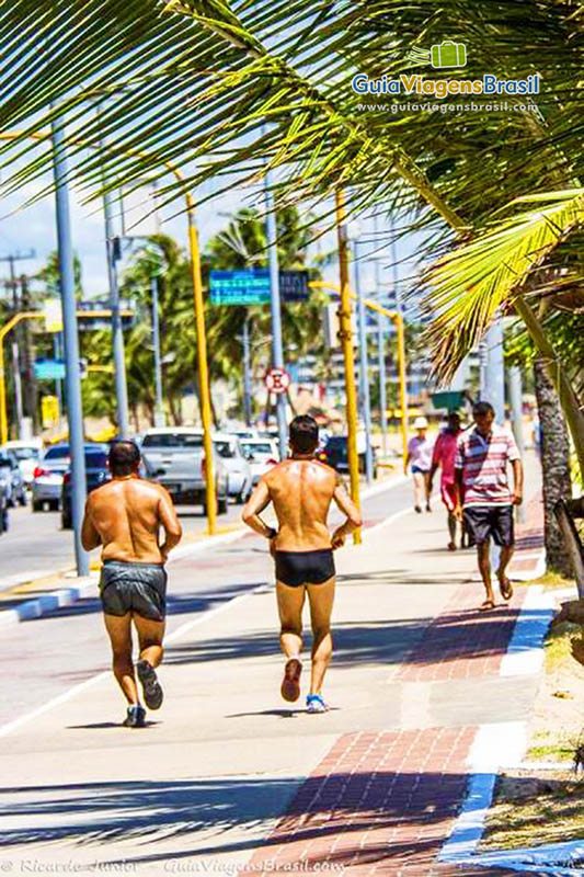 Imagem de dois moradores correndo na orla da Praia de Ponta Verde, em Maceió, Alagoas, Brasil.