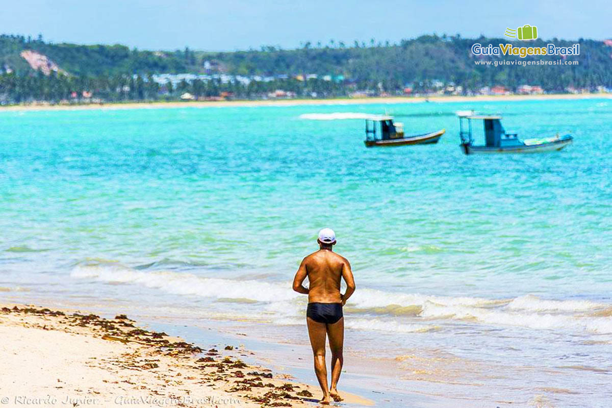 Imagem de morador correndo a beira mar e curtindo a paisagem do barcos no mar, na Praia de Ponta Verde, em Maceió, Alagoas, Brasil.