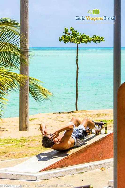 Imagem de morador local fazendo abdominais em aparelho da Praia de Ponta Verde, em Maceió, Alagoas.