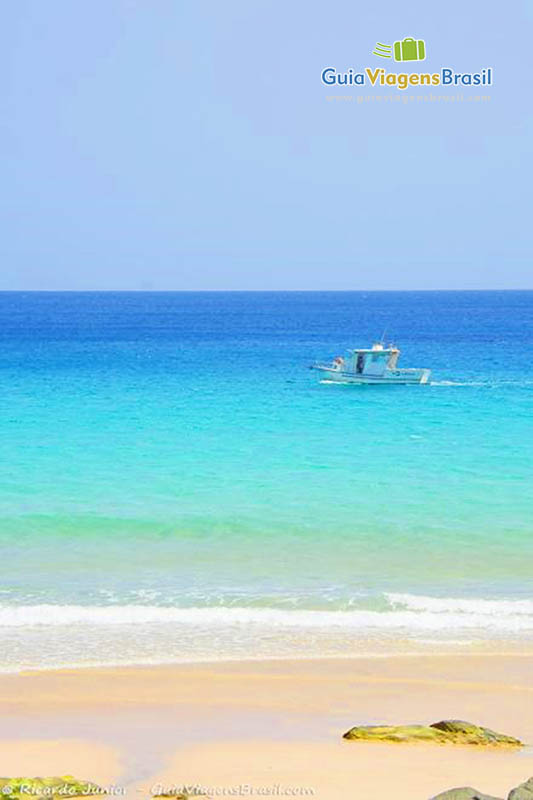 Imagem de um barco pescador parado no alto mar, em Fernando de Noronha, Pernambuco, Brasil.