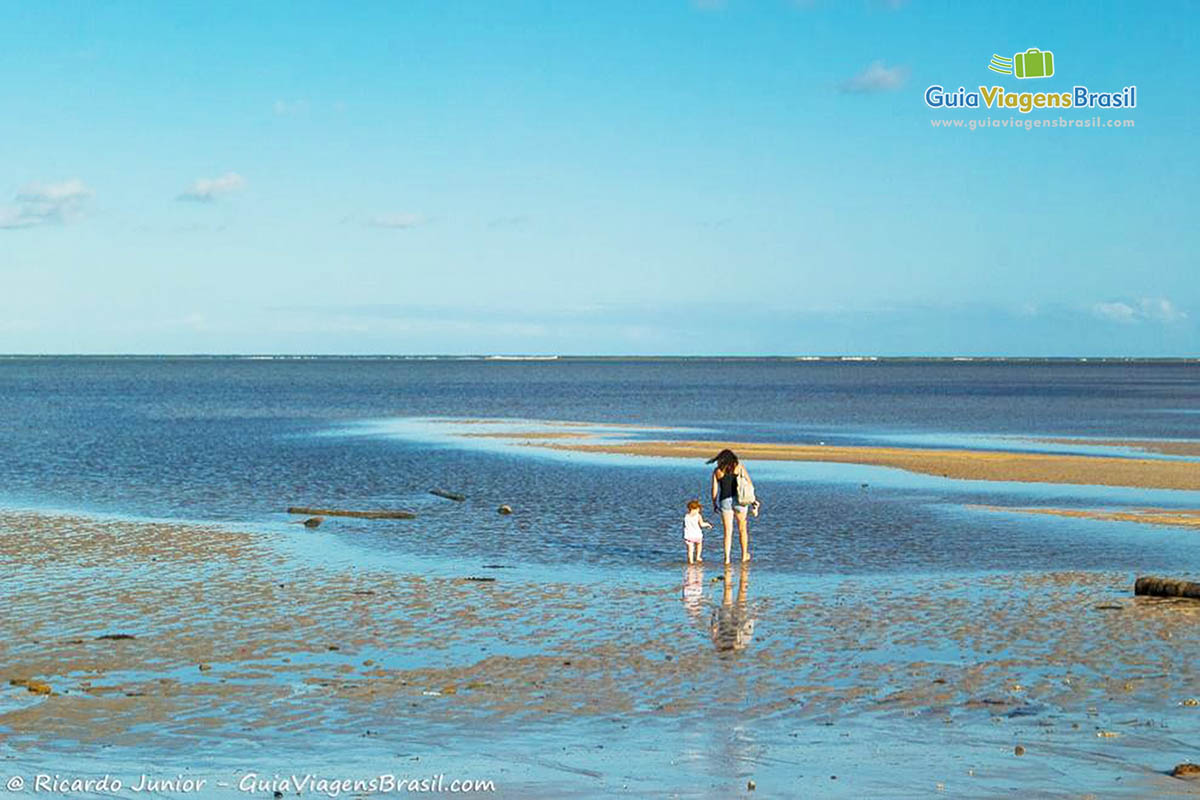 Imagem de mãe e filha aproveitando as águas mornas da Praia de Tatuamunha, em Alagoas.