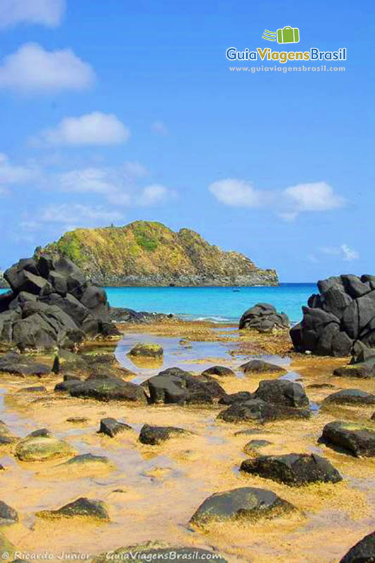 Imagem das rochas escuras, constratando com a cor do mar que é maravilhoso, na Praia do Cachorro, em Fernando de Noronha, Pernambuco, Brasil.