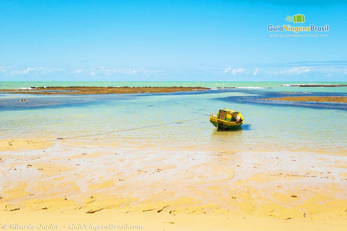 Imagem de barco de pescador parado na beira do mar na Praia do Espelho.