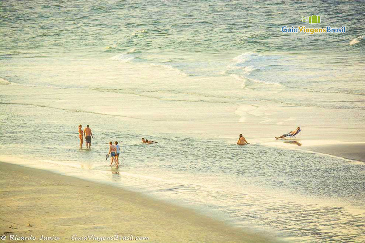 Imagem de turistas na se deliciando na piscina natural, na Praia do Forte, Ilha do Mel Paraná, Brasil.