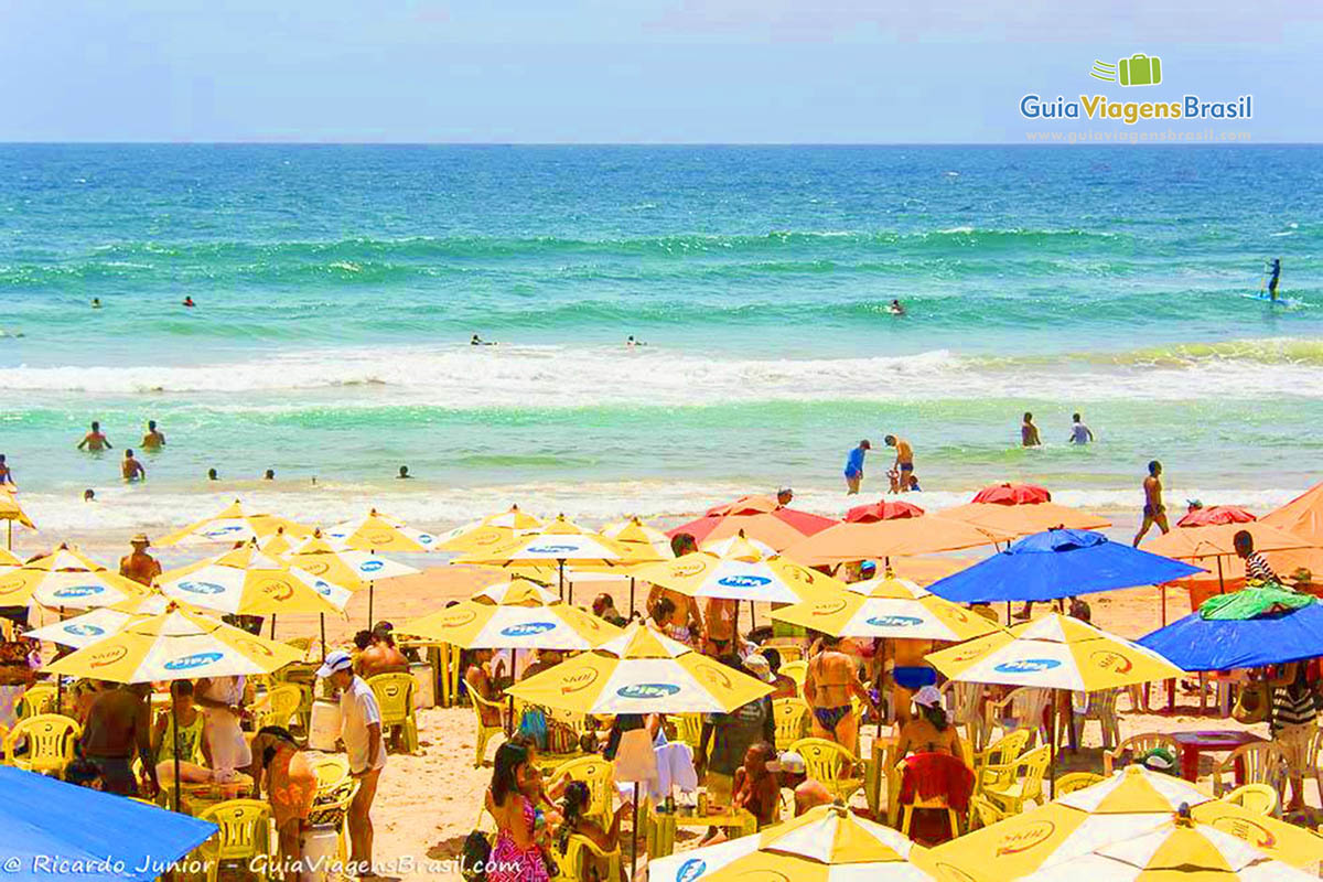 Imagem de turistas aproveitando um belo dia de praia.