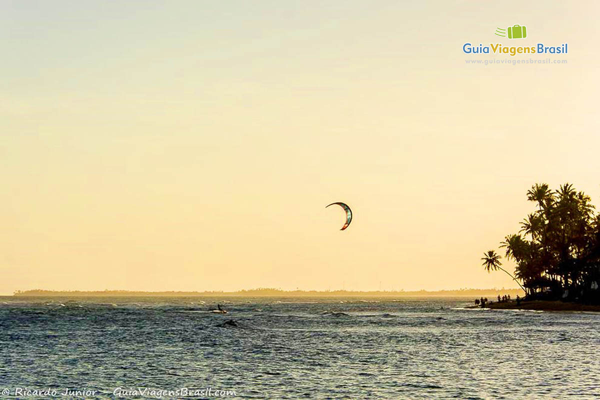 Imagem da uma pessoa praticando kite surf na linda Praia do Forte.