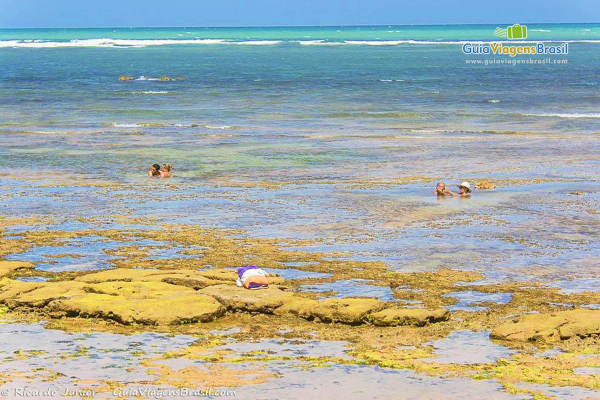 Imagem de turistas de deliciando na piscina natural.