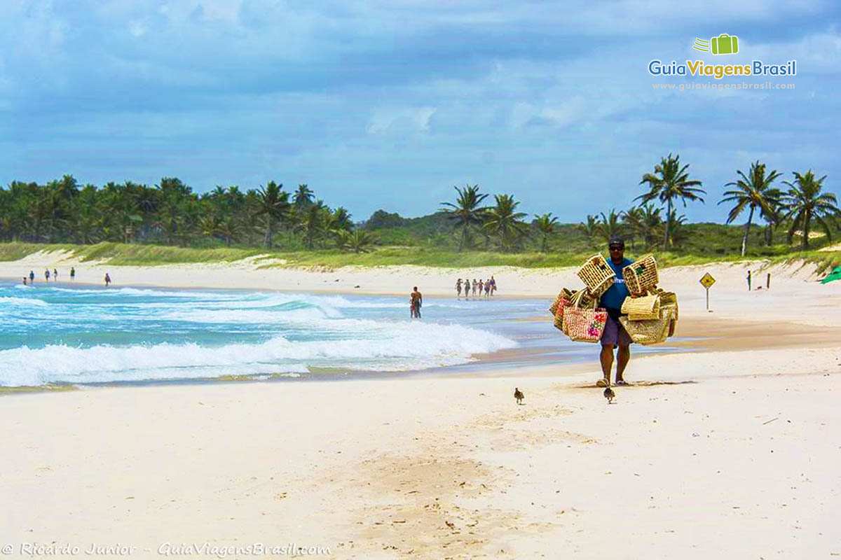 Imagem de vendedor ambulante com cestos para vender na encantadora Praia do Frances.