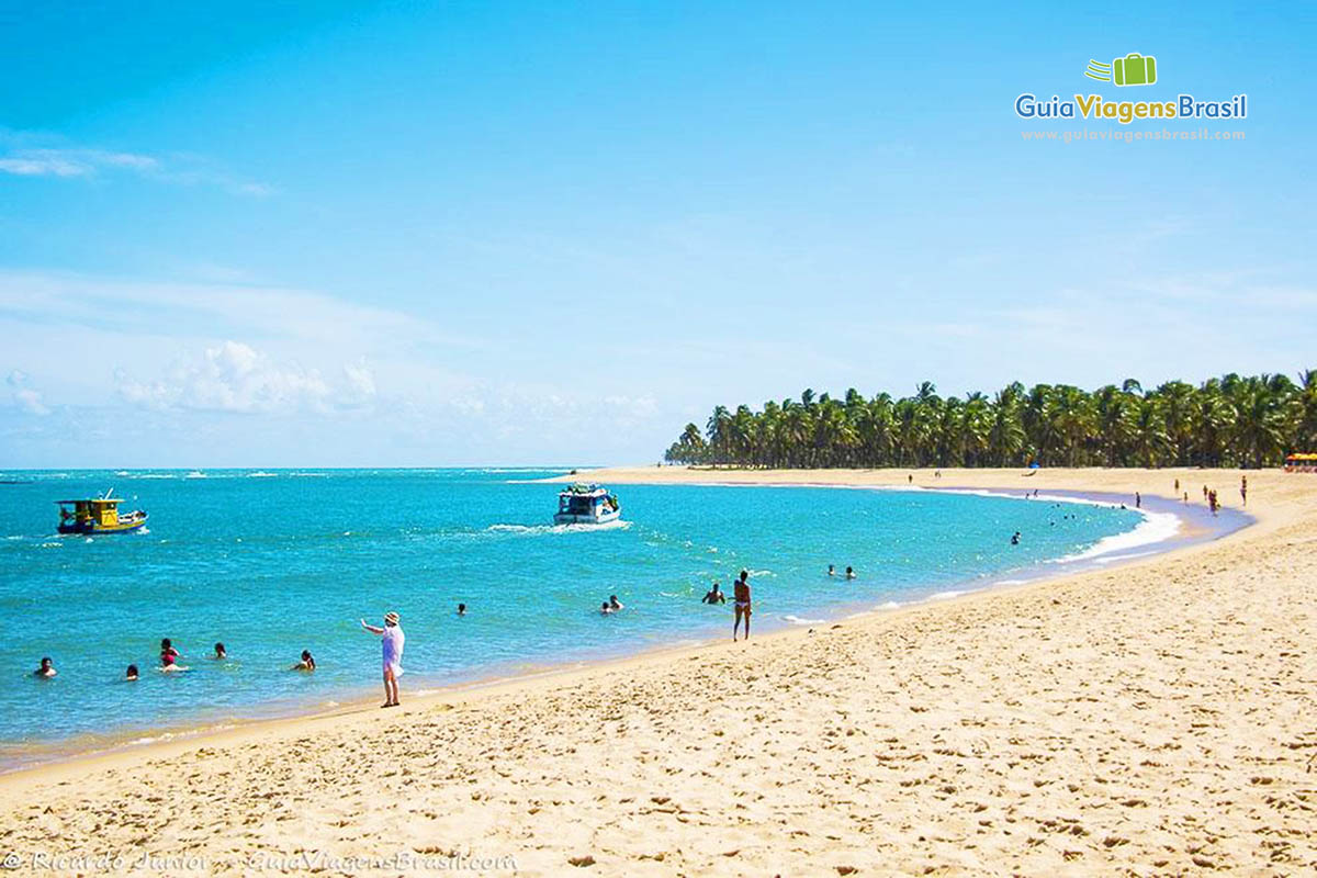 Imagem de turistas nas águas cristalinas, da Praia do Gunga, em Maceió, Alagoas, Brasil.