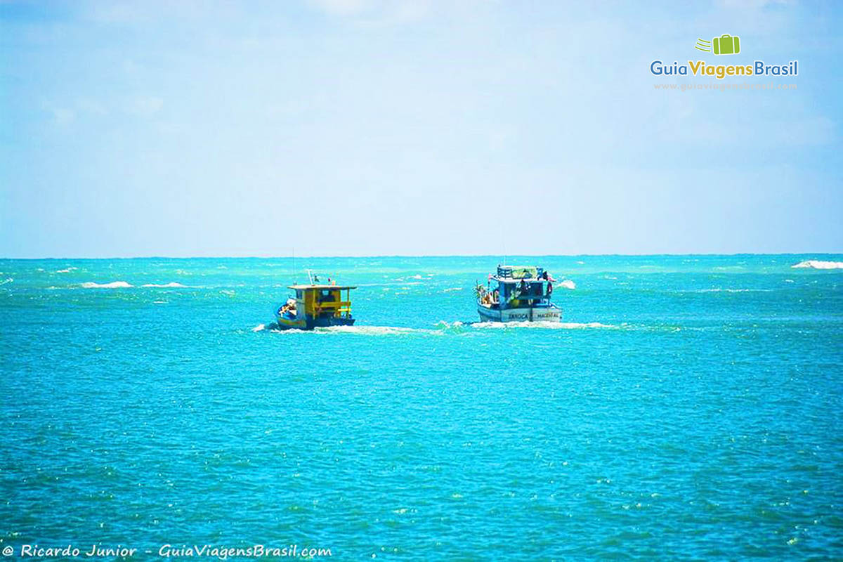 Imagem de dois barcos de pescadores em direção ao alto mar para mais um dia de pesca na Praia do Gunga, em Maceió, Alagoas, Brasil.