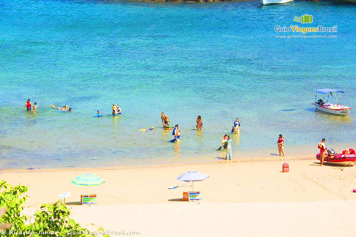 Imagem da praia Porto de Santo Antônio, vários turista com snorkel aproveitando as águas cristalinas para mergulhar, em Fernando de Noronha, Pernambuco, Brasil.