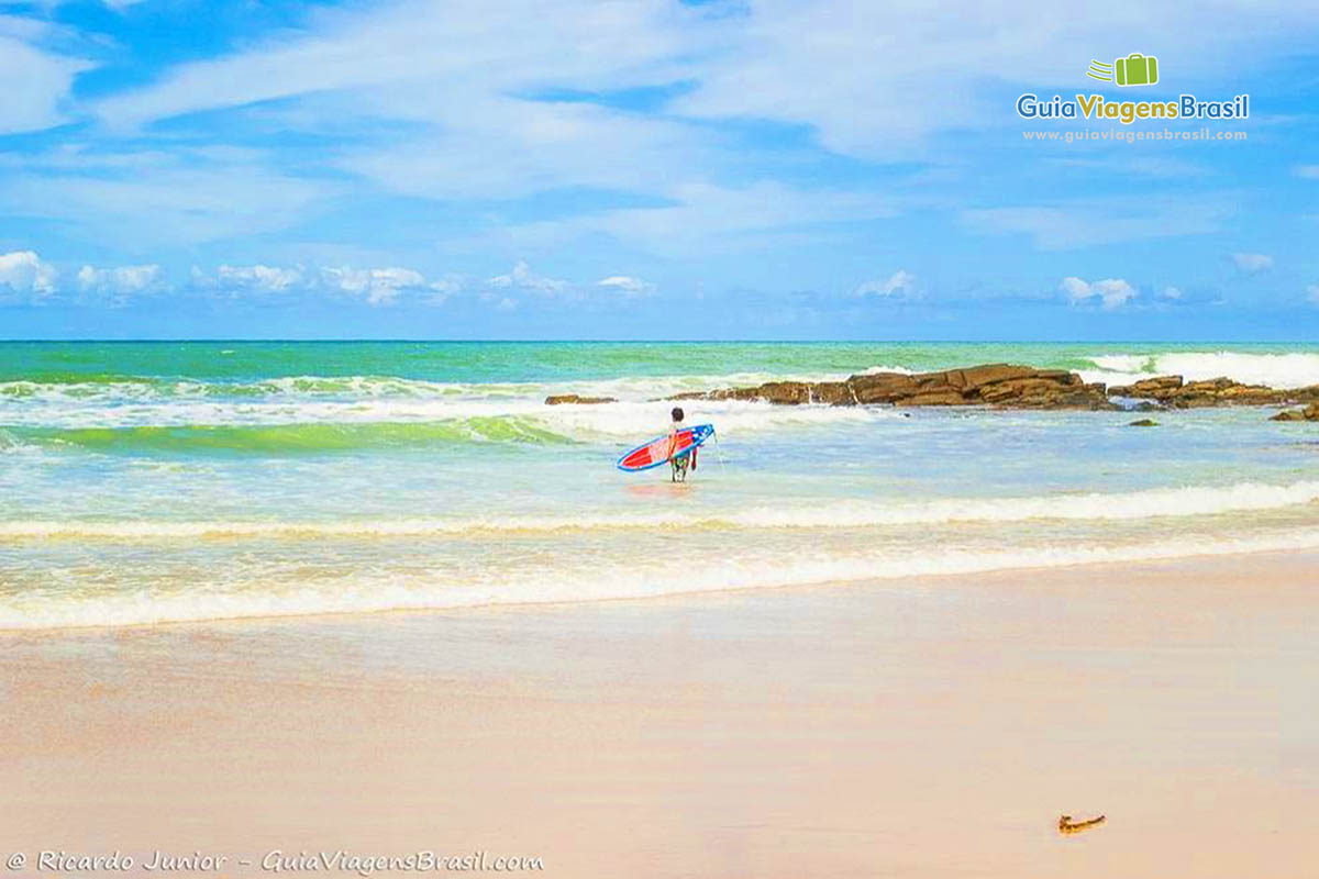 Imagem de surfista entrando no lindo mar da Praia do Resende.