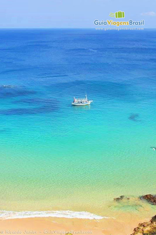 Imagem do alto do mar colorido e barcos nestas lindas águas, na Praia do Sancho, em Fernando de Noronha, Pernambuco, Brasil.