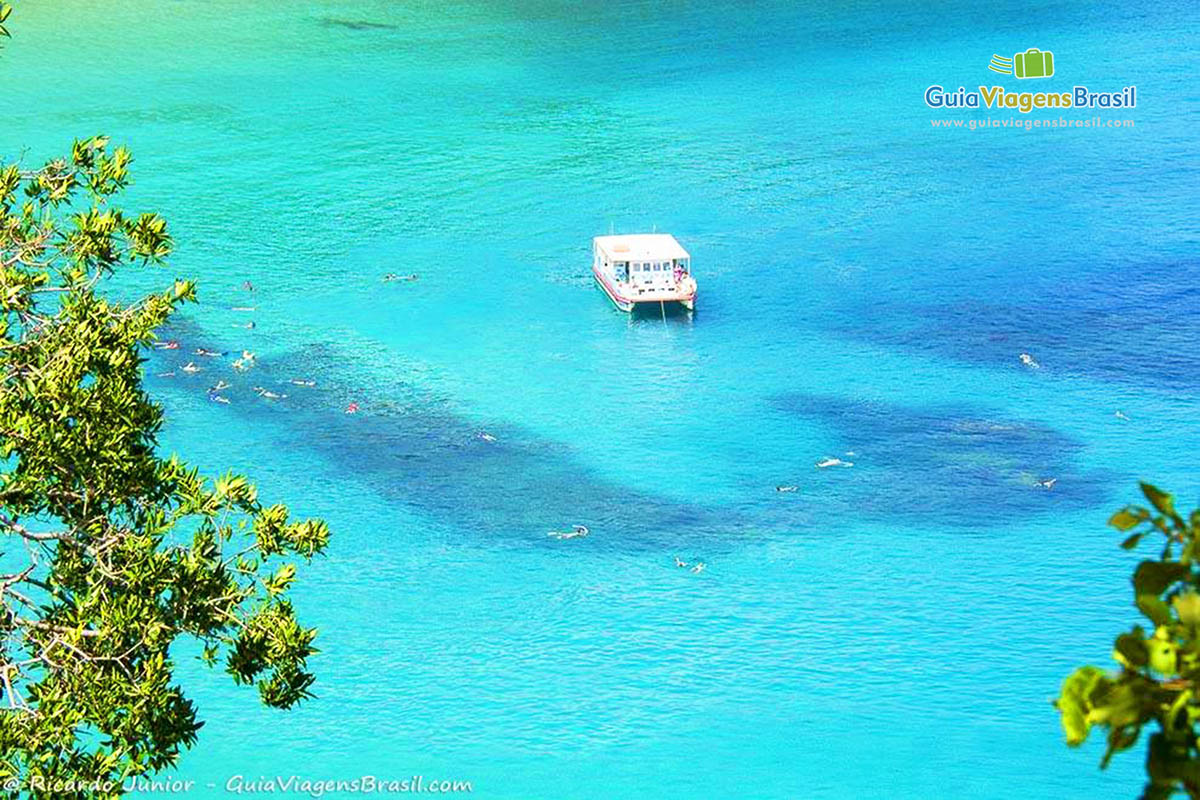 Imagem do alto de turistas mergulhando em alto mar, ao redor no barco, em Fernando de Noronha, Pernambuco, Brasil.