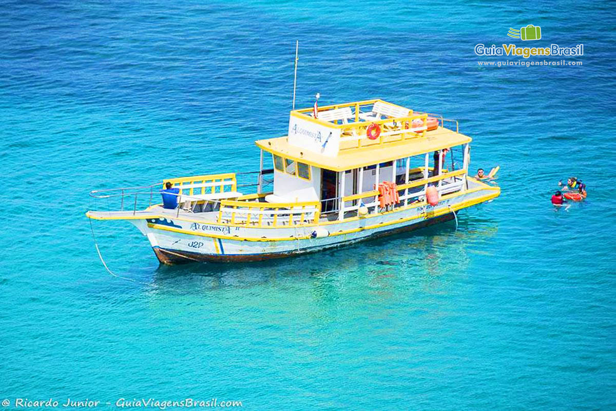 Imagem do barco de passeio vazio aguardando turistas que foram nadar, na Praia do Sancho, em Fernando de Noronha, Pernambuco, Brasil.