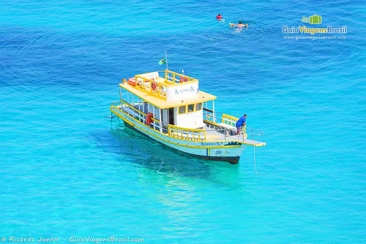 Imagem de barco parados nas águas transparentes da Praia do Sancho, em Fernando de Noronha, Pernambuco, Brasil.