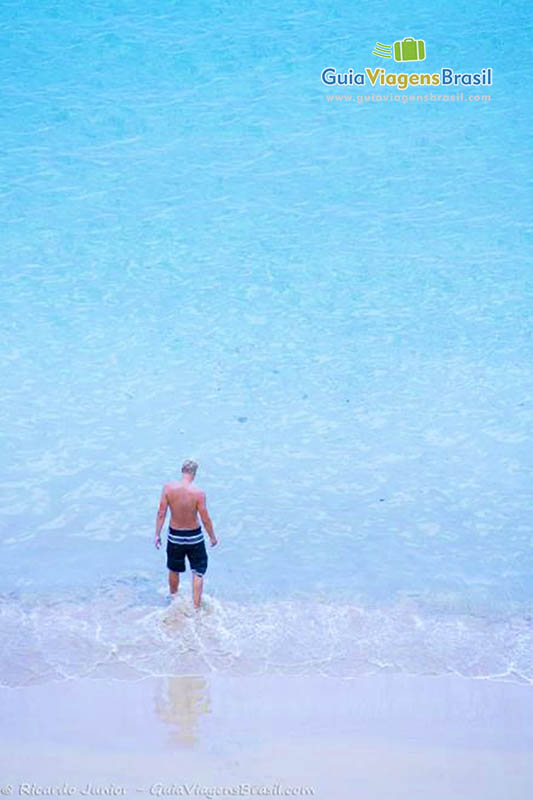 Imagem de turista na beira mar entrando nesse mar maravilhoso da Praia do Sancho, em Fernando de Noronha, Pernambuco, Brasil.