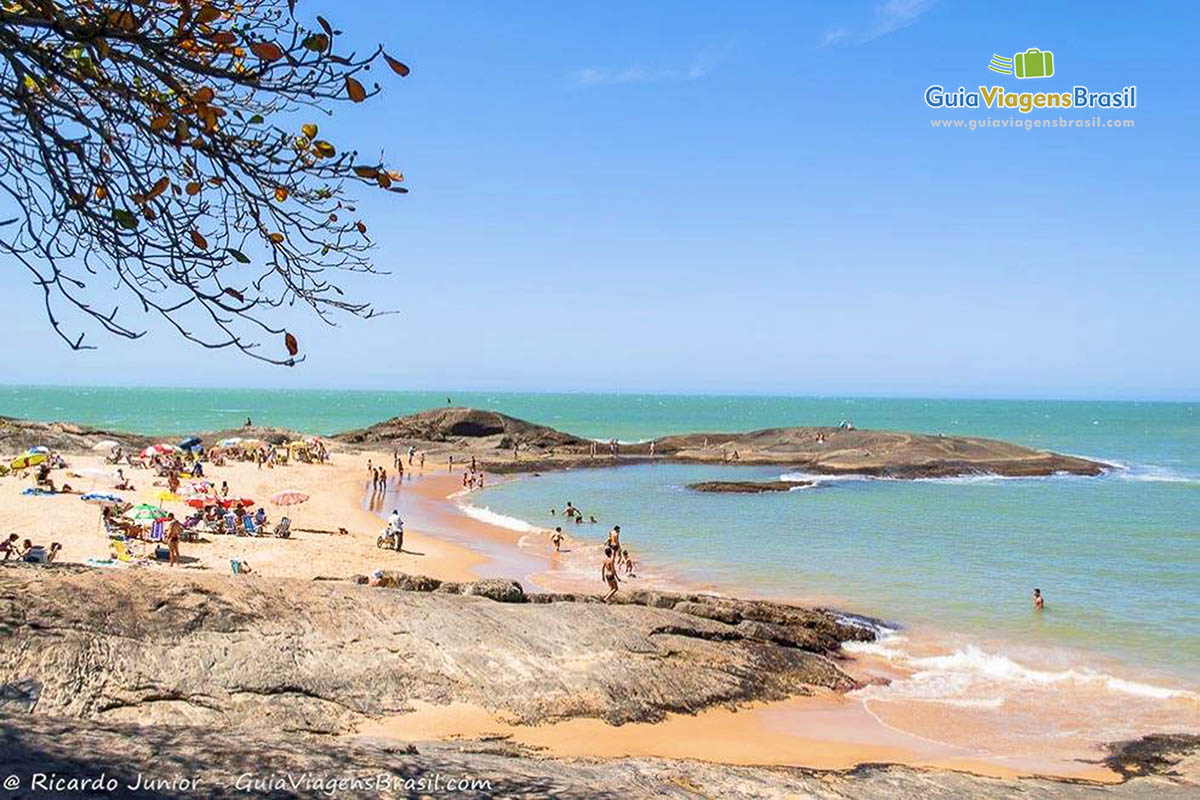 Imagem de pais com filhos na pequena Praia dos Namorados.