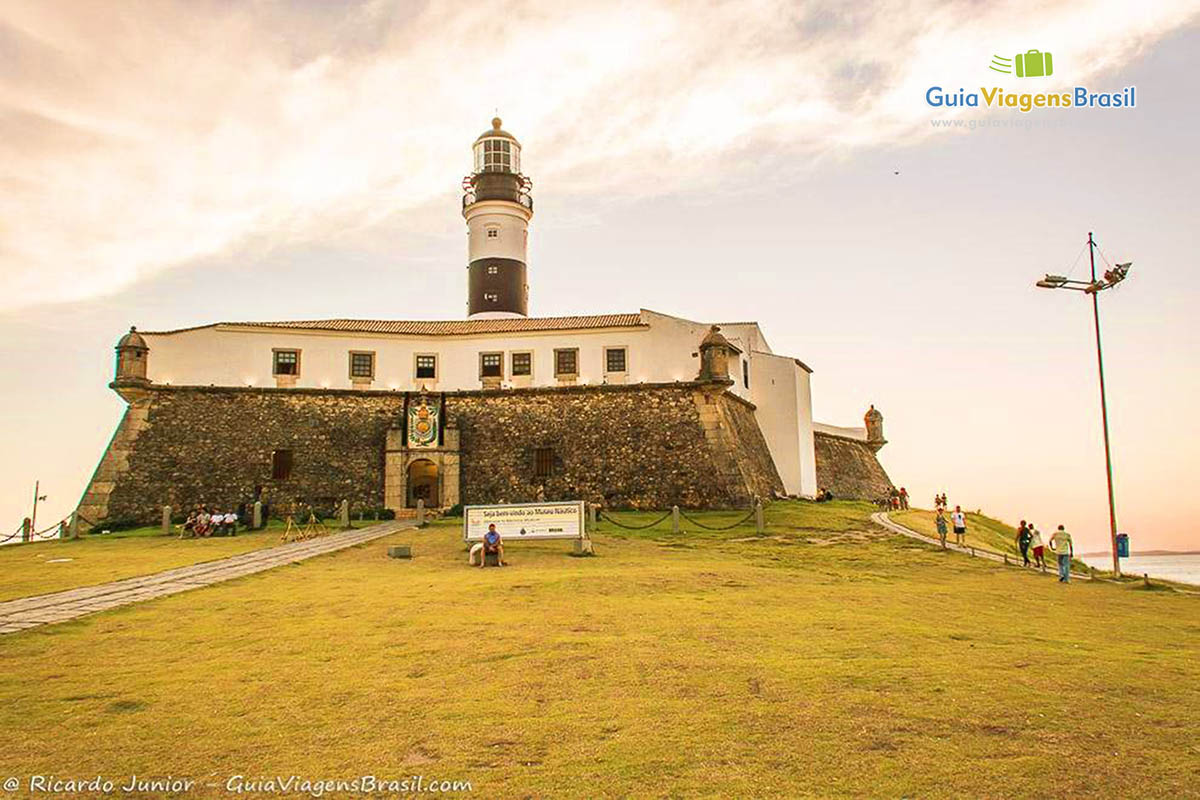 Imagem de turistas visitando o Forte e o Farol.